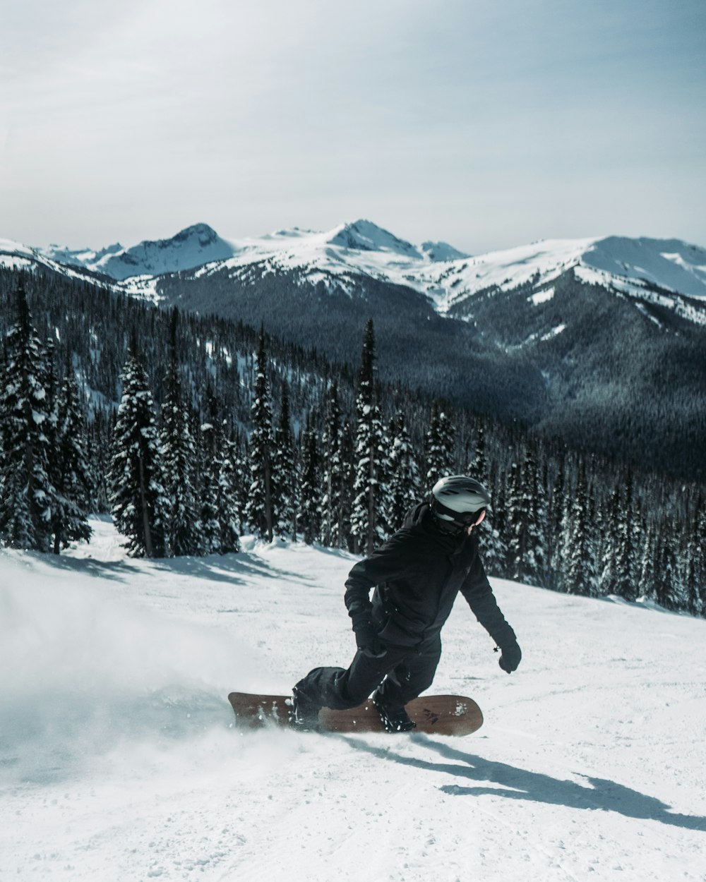 Foto Un hombre montando una tabla de snowboard por una pendiente cubierta  de nieve – Imagen Canadá gratis en Unsplash
