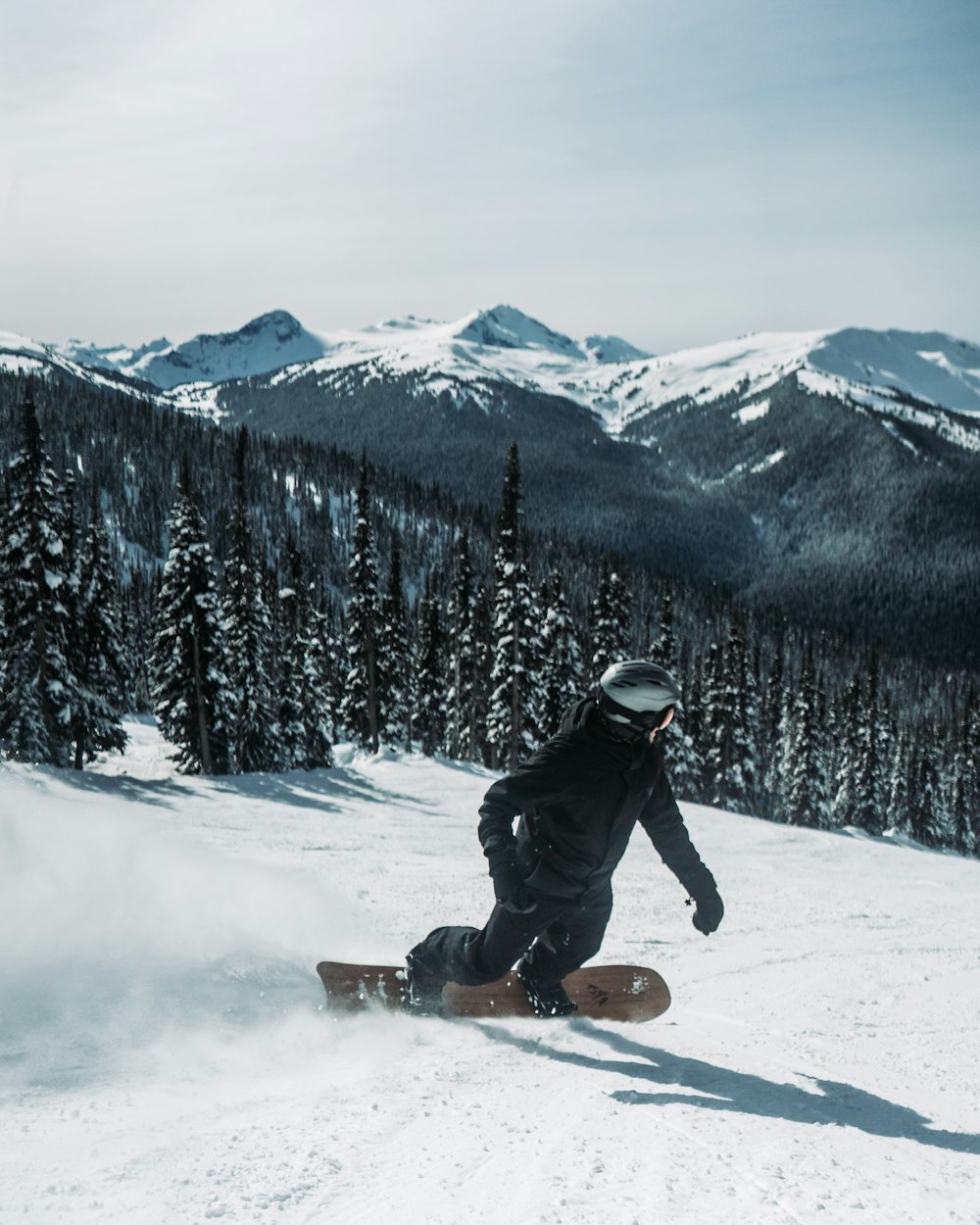 a man riding a snowboard down a snow covered slope