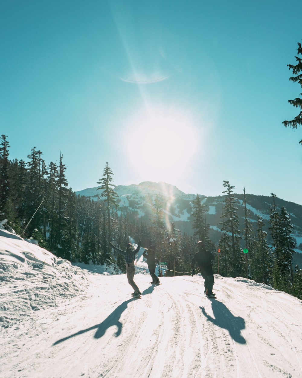 a couple of people riding skis down a snow covered slope