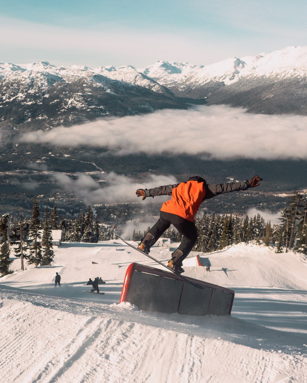 a man riding a snowboard down the side of a snow covered slope