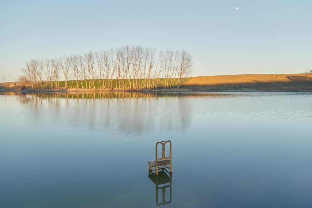 a chair sitting in the middle of a lake