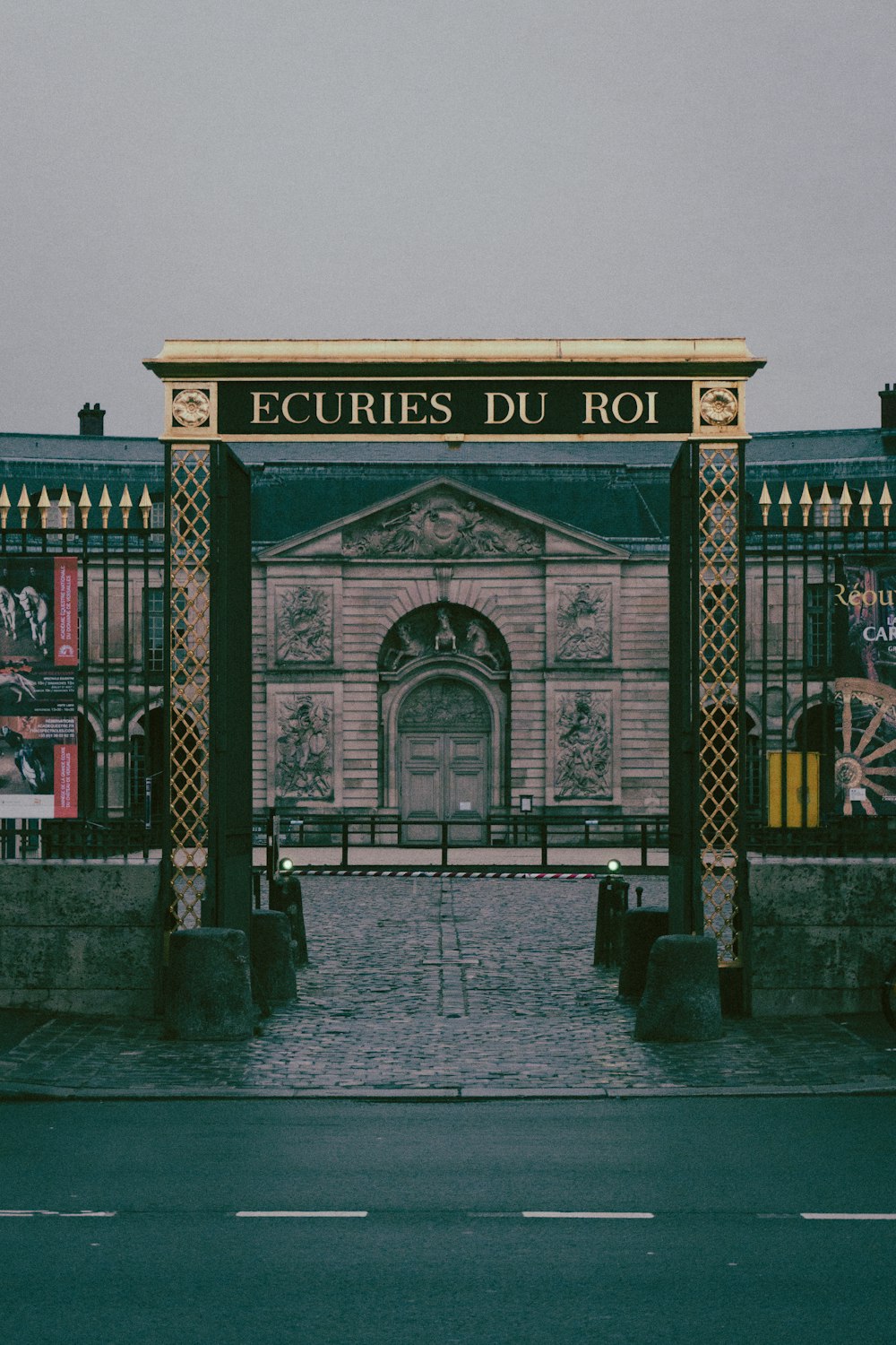 a building with a gate and a clock on the front of it