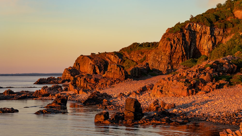 a rocky beach with a mountain in the background