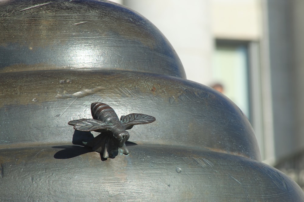 a close up of a metal object with a bee on it