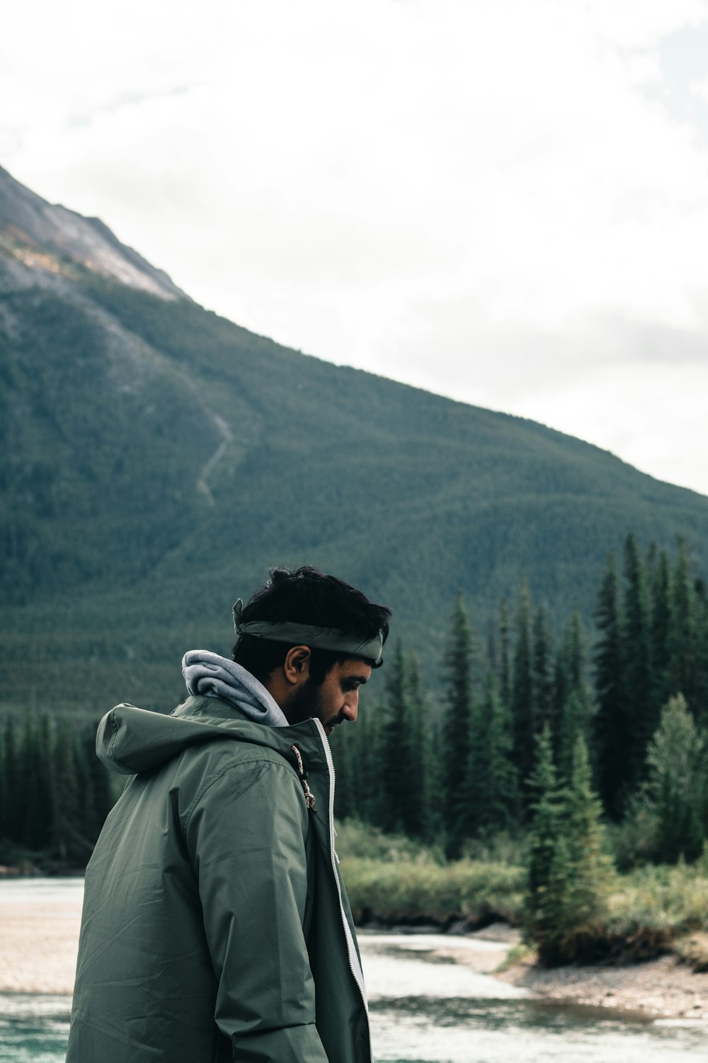 Un homme debout devant une rivière