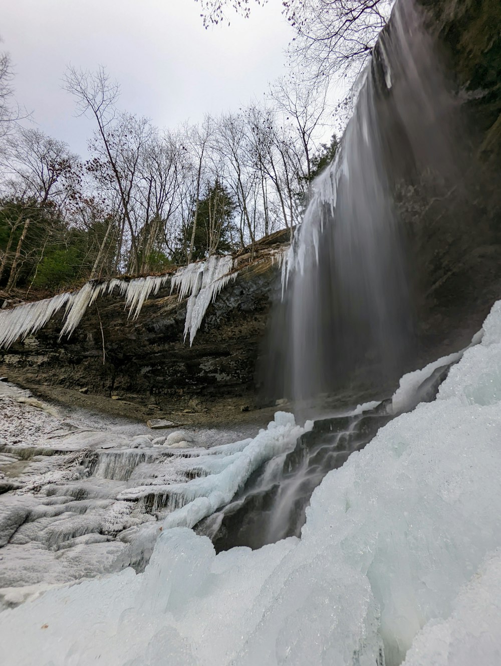 a waterfall with ice hanging off of it's sides