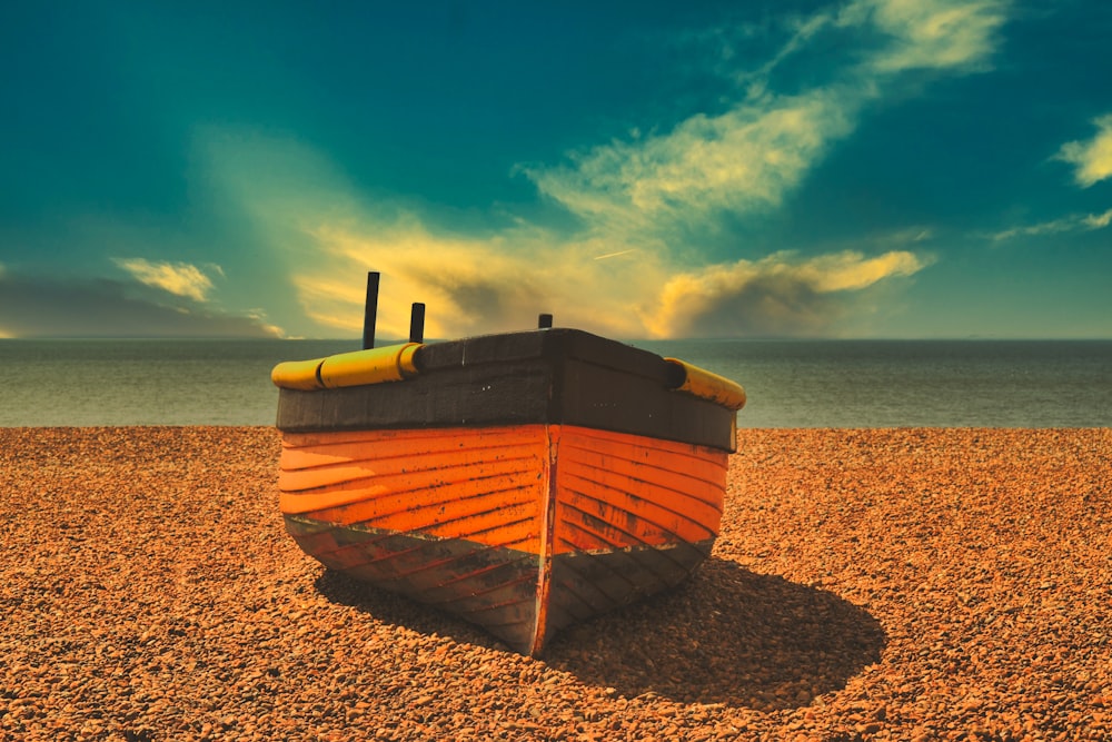 a boat sitting on top of a sandy beach