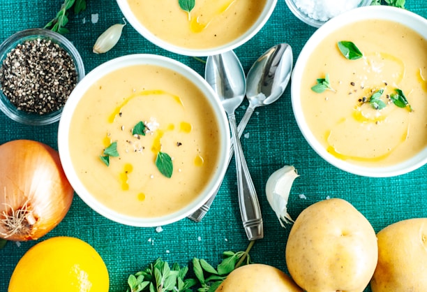 a table topped with bowls of soup and vegetables