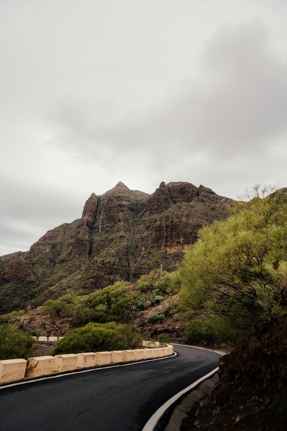 a winding road with a mountain in the background