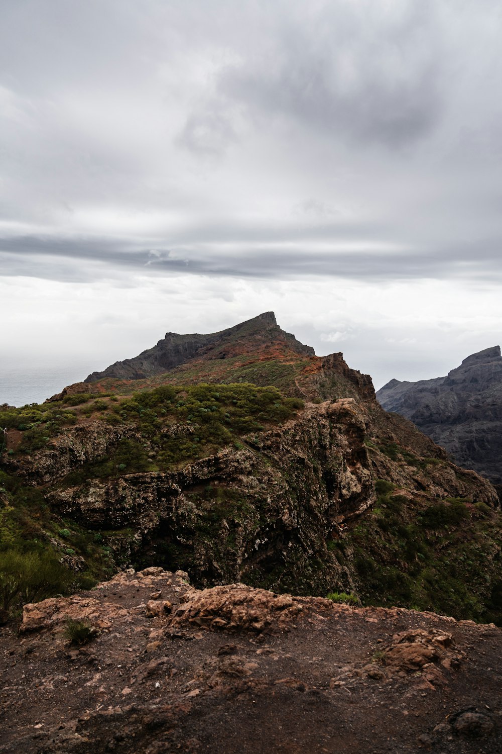 a large mountain with a grassy area on top of it