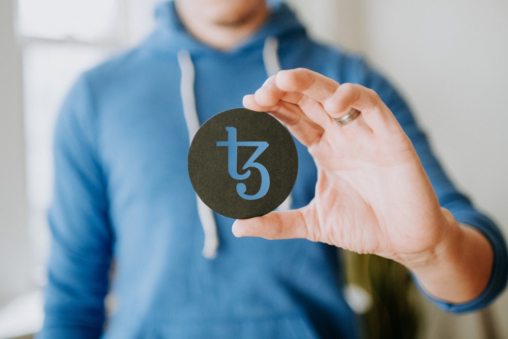 a person holding up a black paper with the number thirteen on it