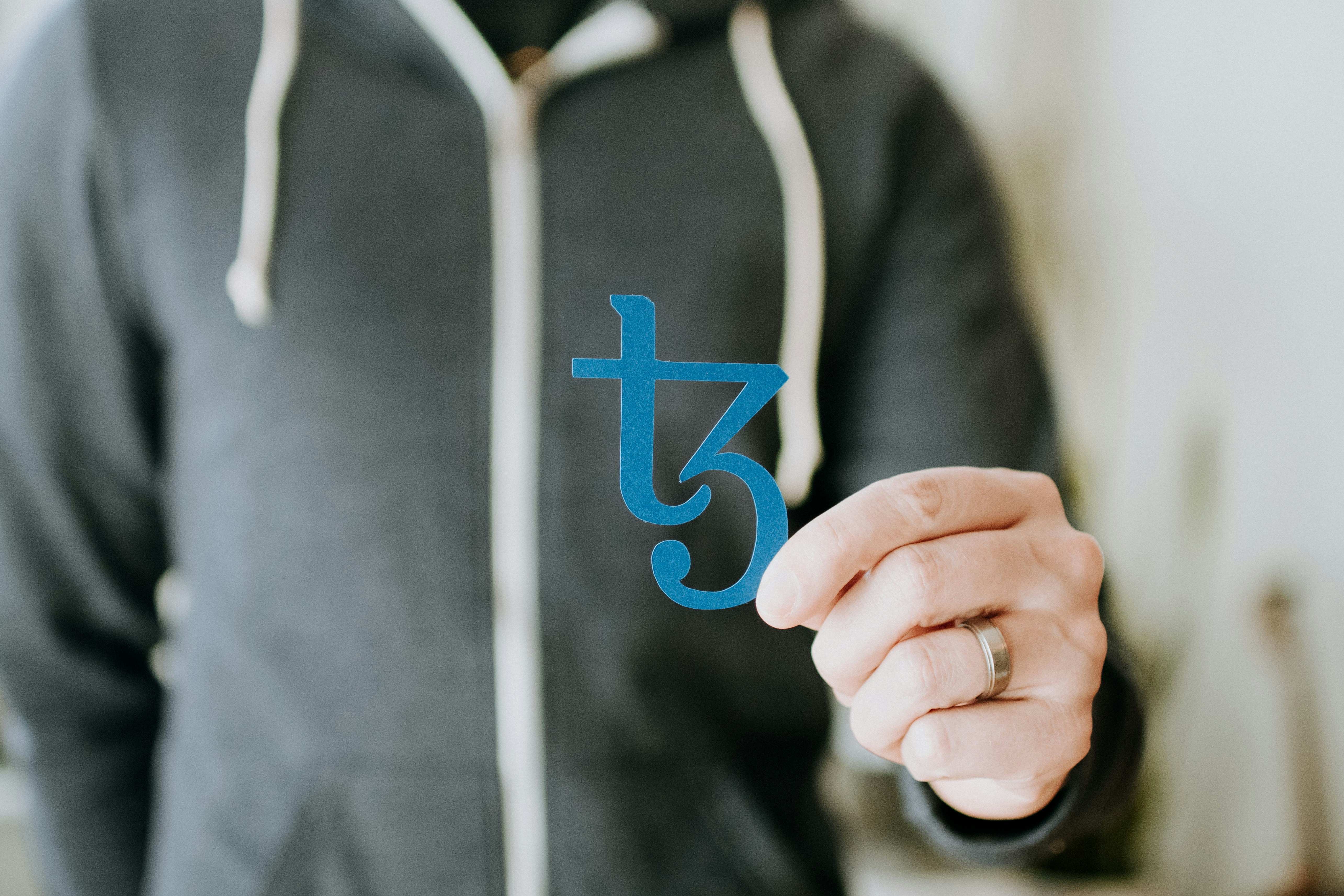 Man holding tezos logo