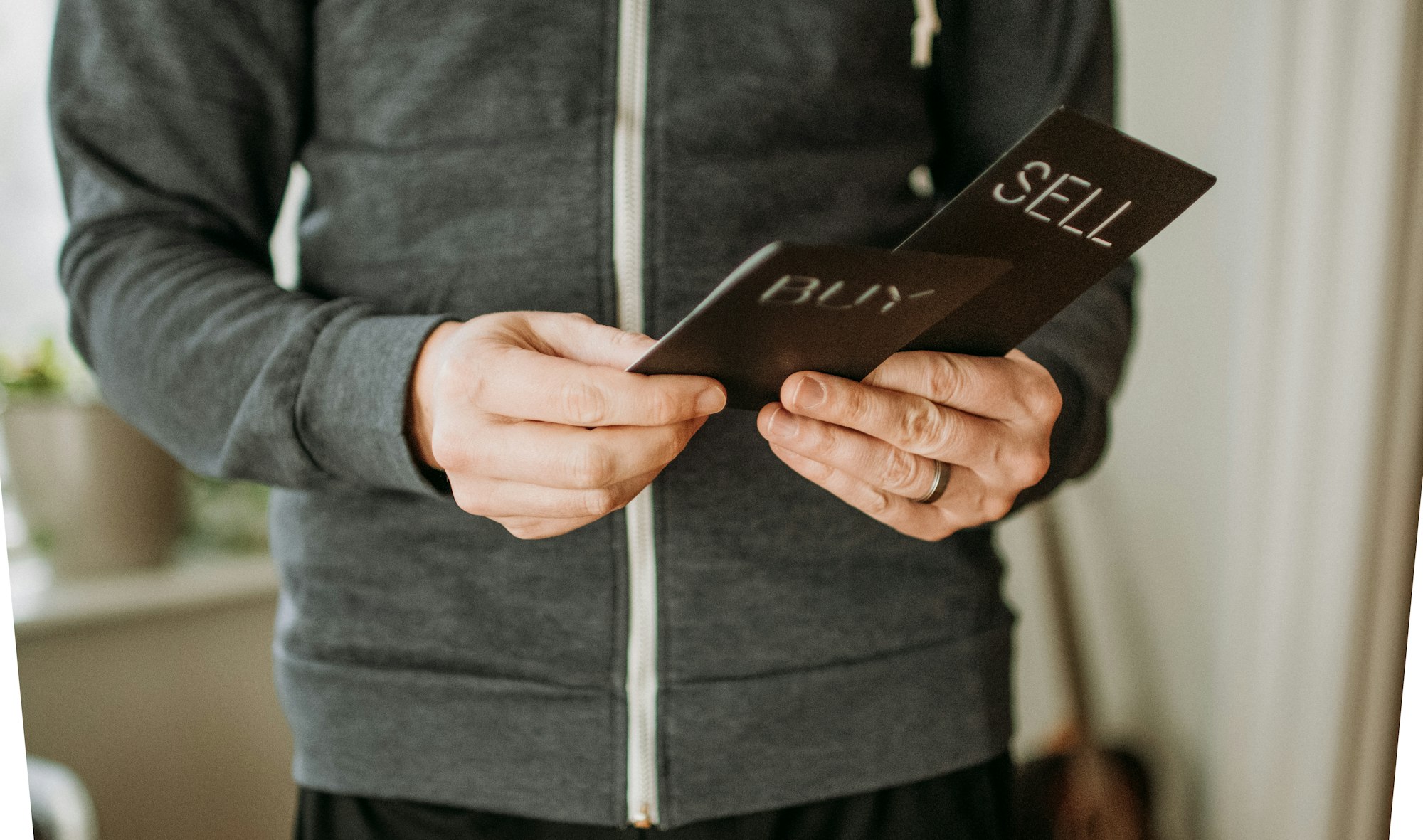 Man holding cards reading buy and sell