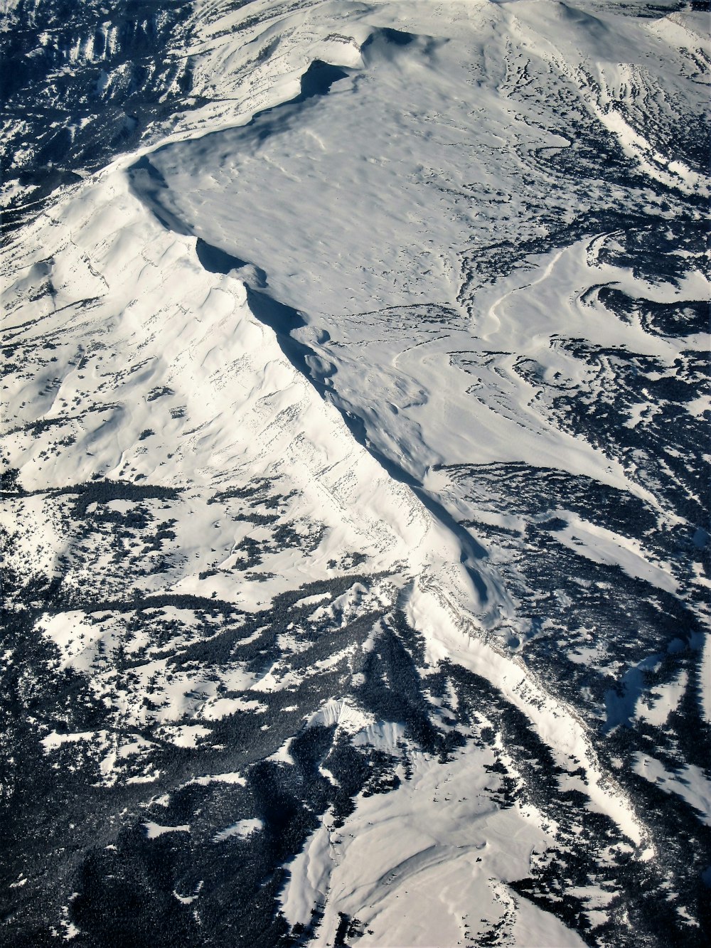 an aerial view of a snow covered mountain