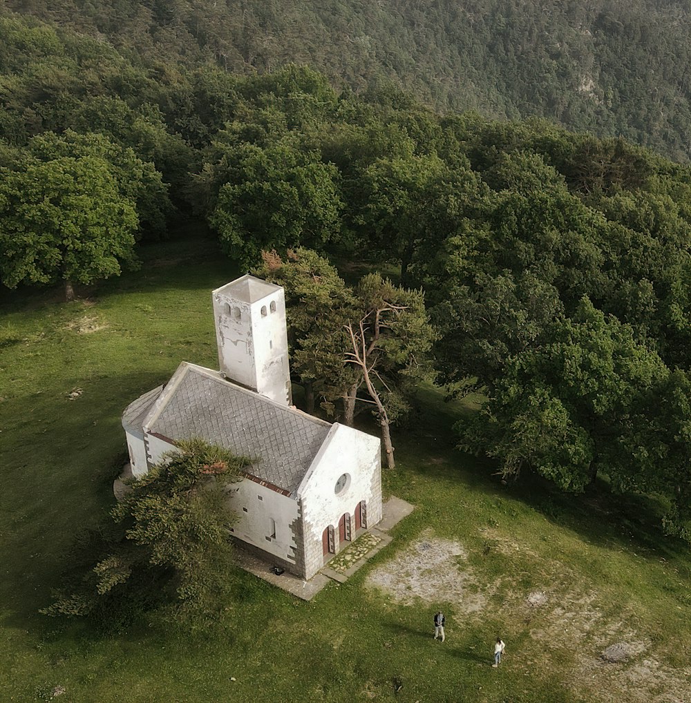 an aerial view of a church surrounded by trees