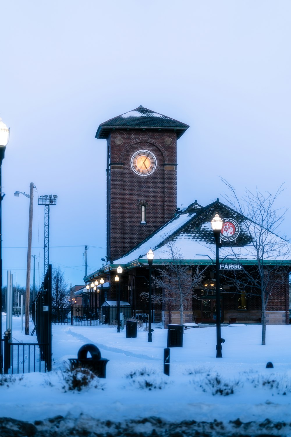 a clock tower in the middle of a snowy street