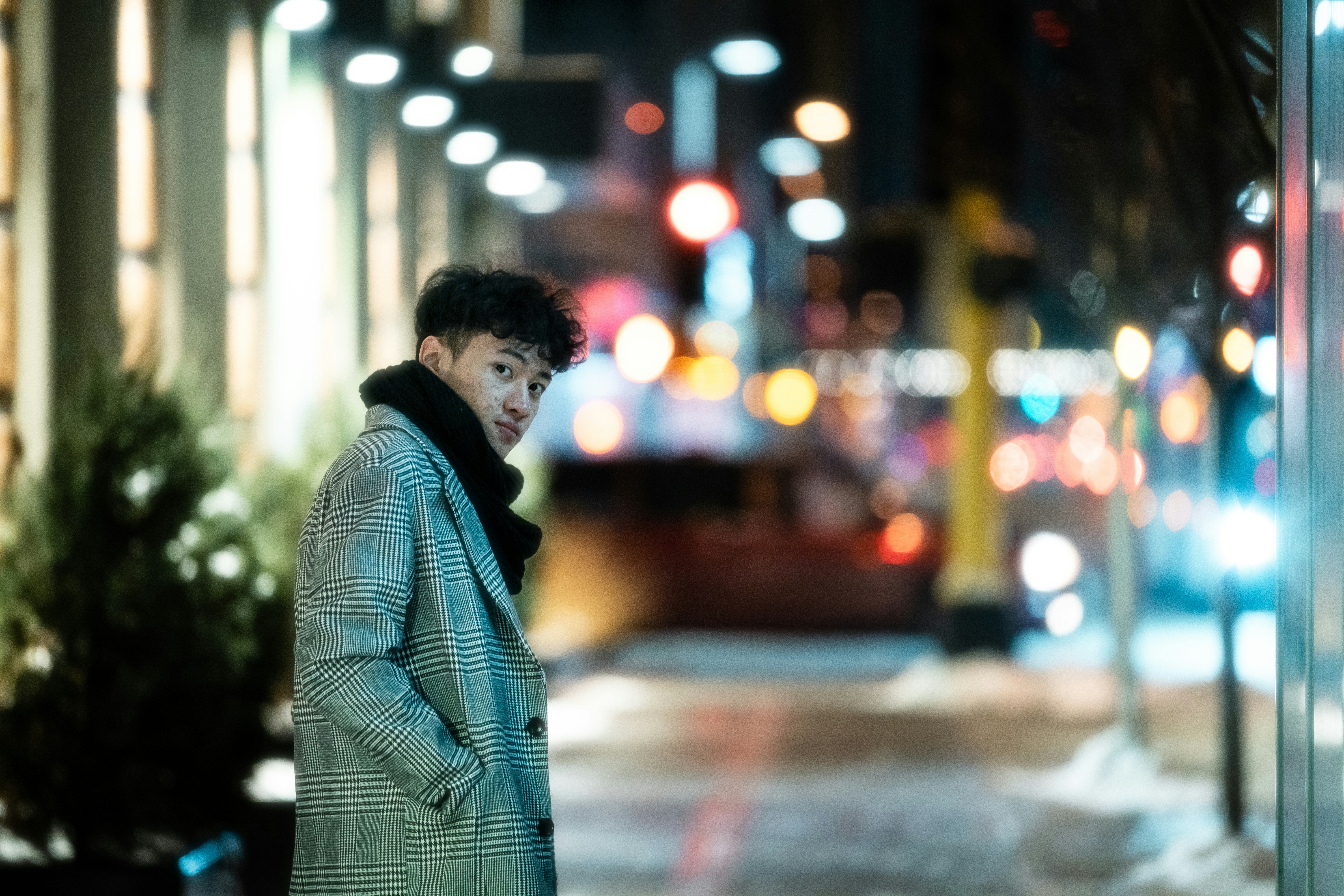 a man standing on a sidewalk at night