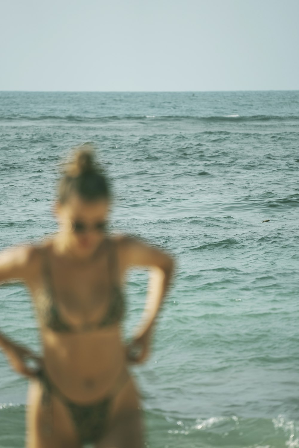 Una mujer en bikini parada en el océano