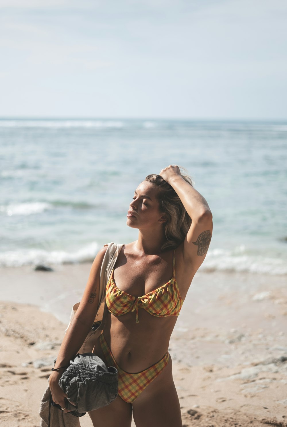 a woman in a bikini standing on a beach