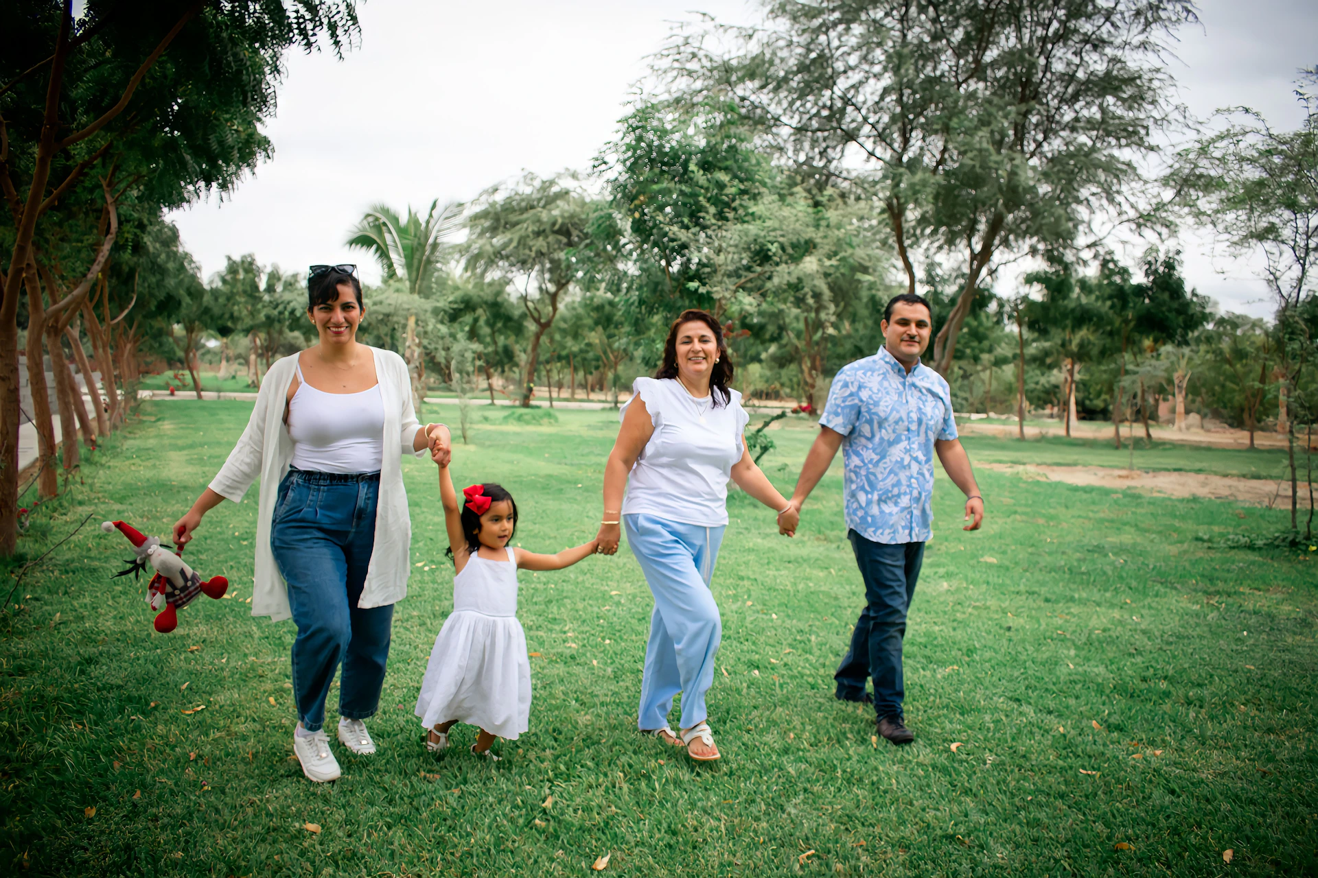 a group of people walking across a lush green field