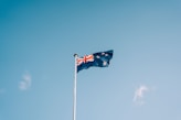 a flag flying in the wind on a clear day