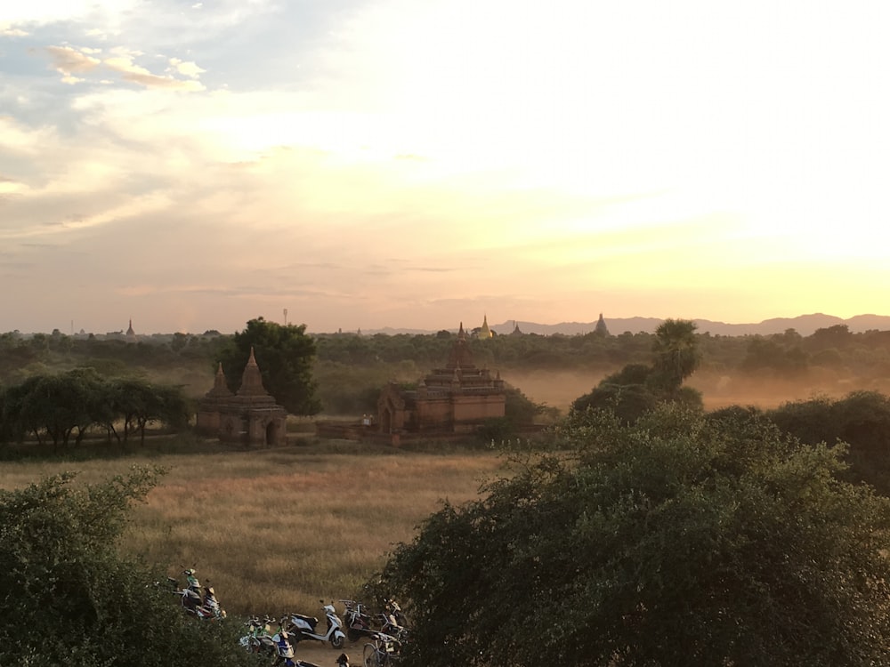 a group of motorcycles parked on top of a dry grass field