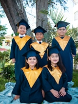 a group of children in graduation gowns posing for a picture