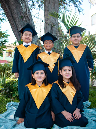 a group of children in graduation gowns posing for a picture