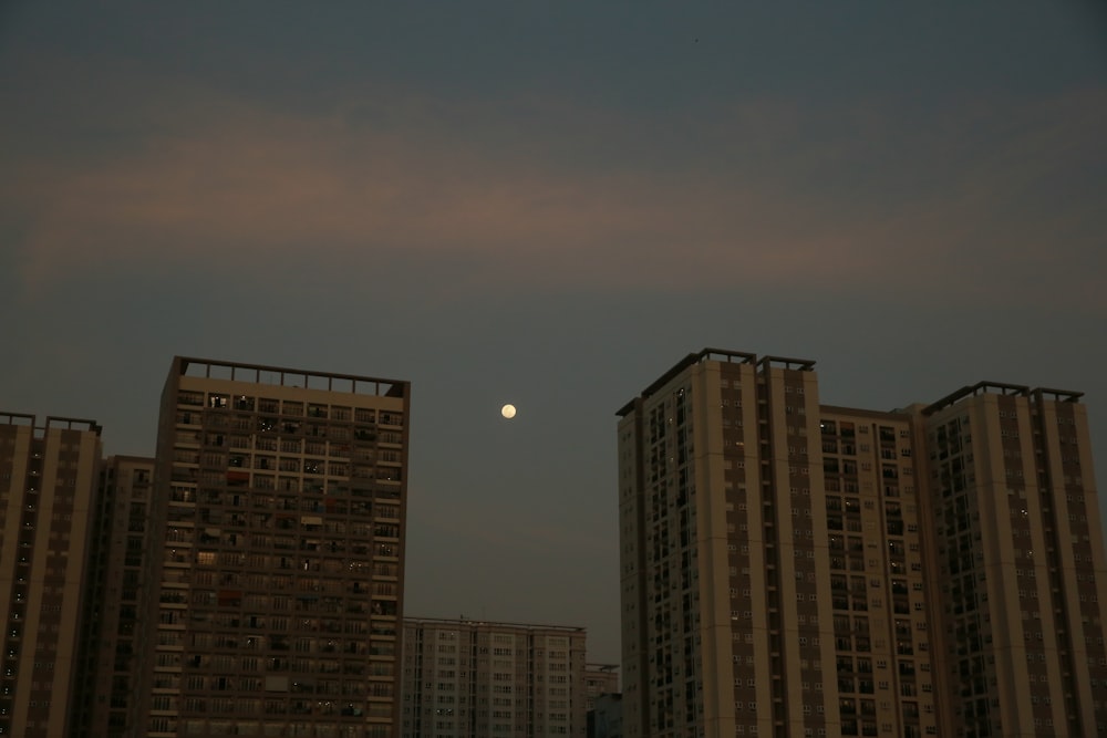 a full moon is seen in the sky over a city