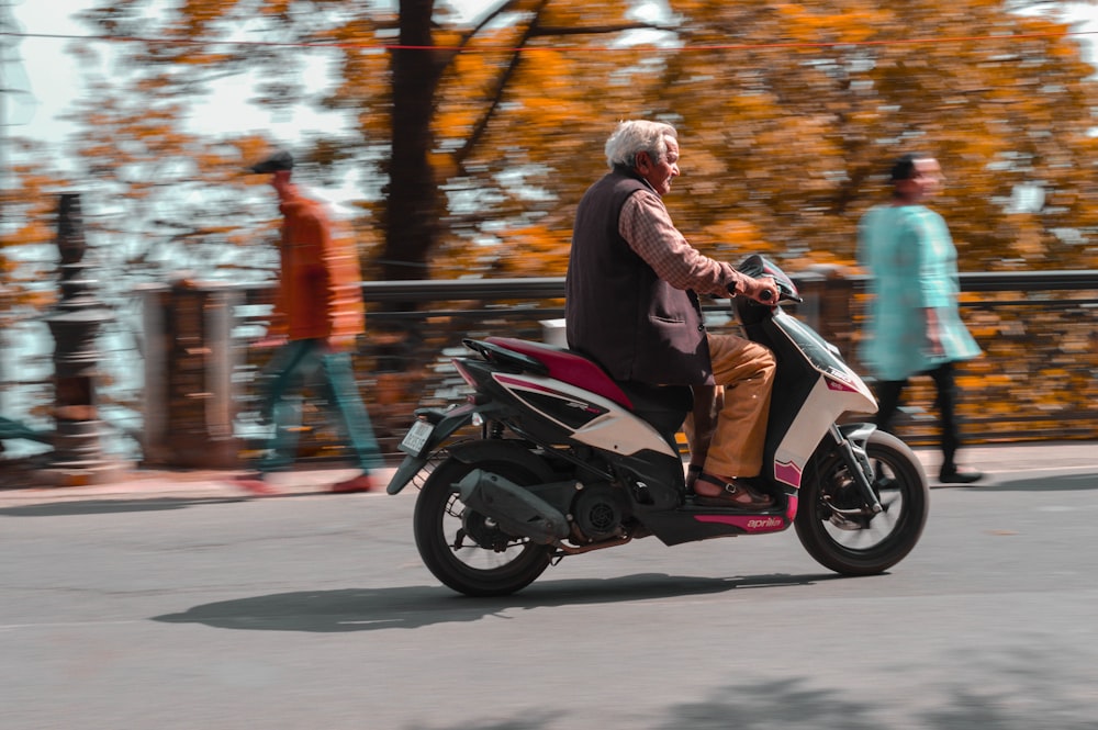 a man riding on the back of a motorcycle down a street