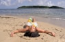 a woman laying on the beach with her head in the sand