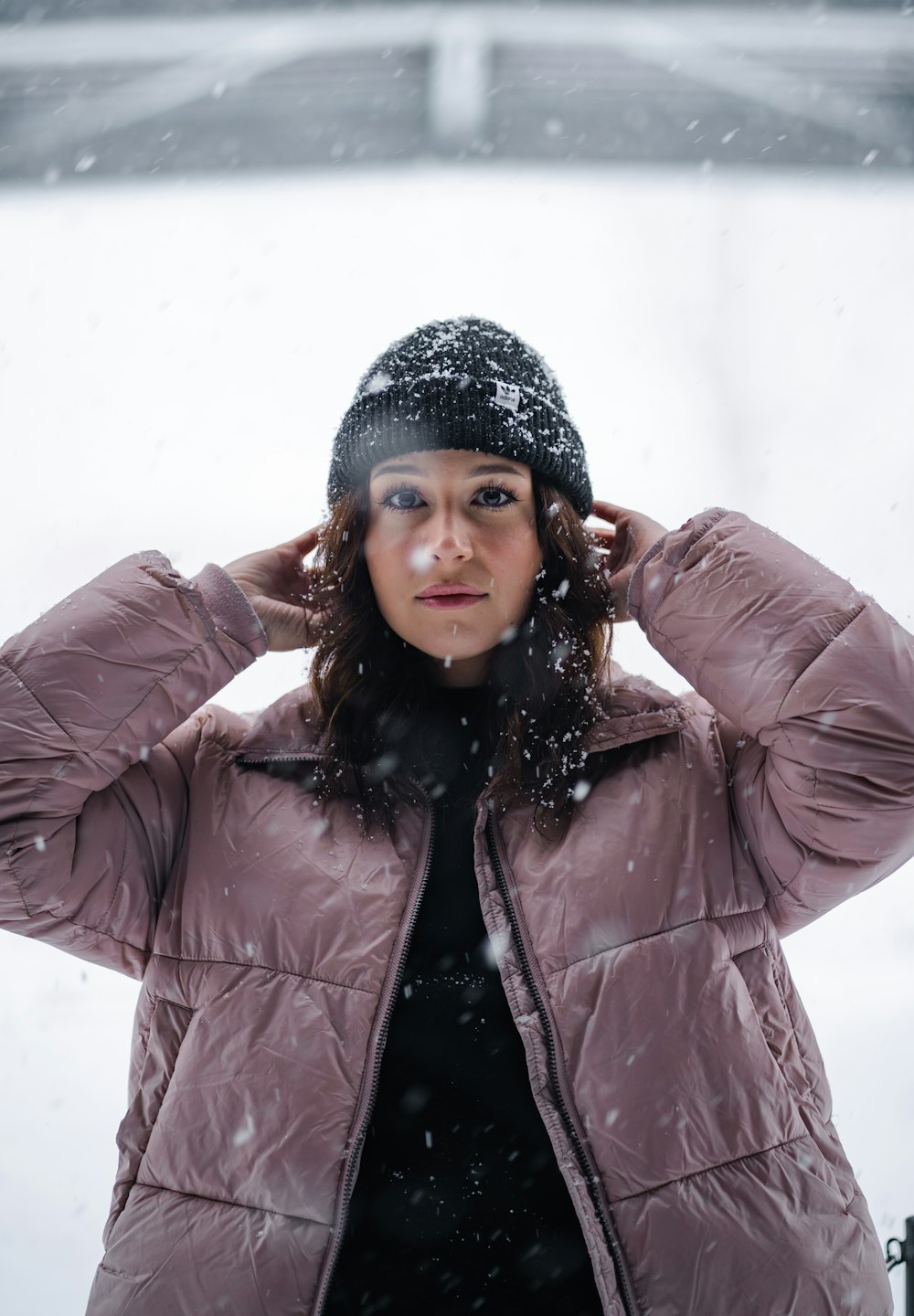 a woman standing in the snow with her hands on her head