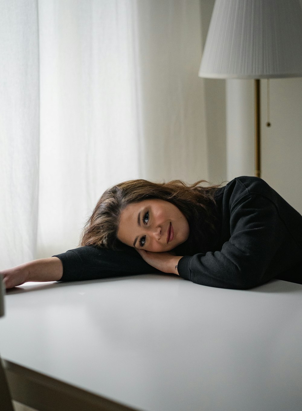 a woman laying her head on a table