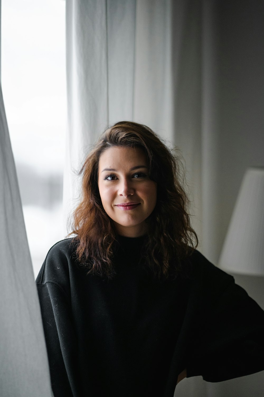 a woman standing in front of a window