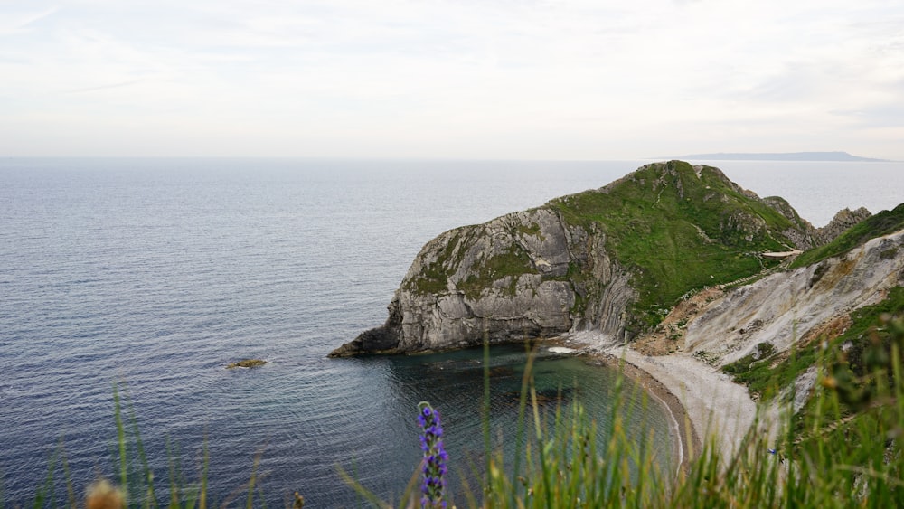 a large body of water surrounded by a lush green hillside