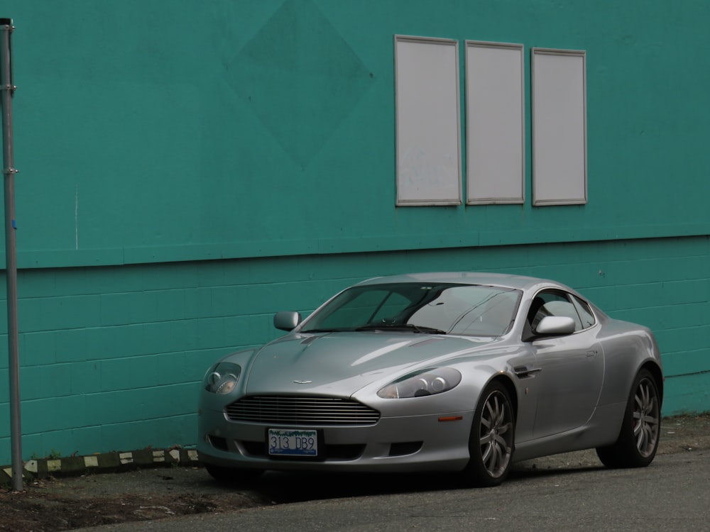 a silver sports car parked in front of a building