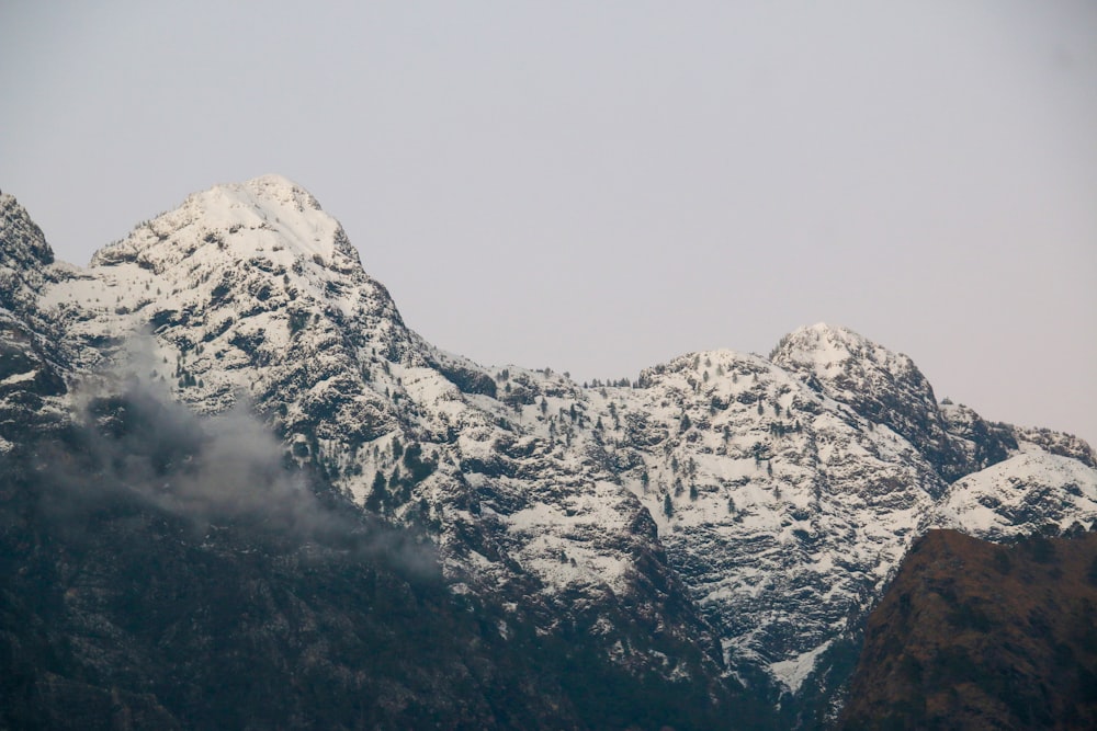 a mountain range covered in snow and clouds