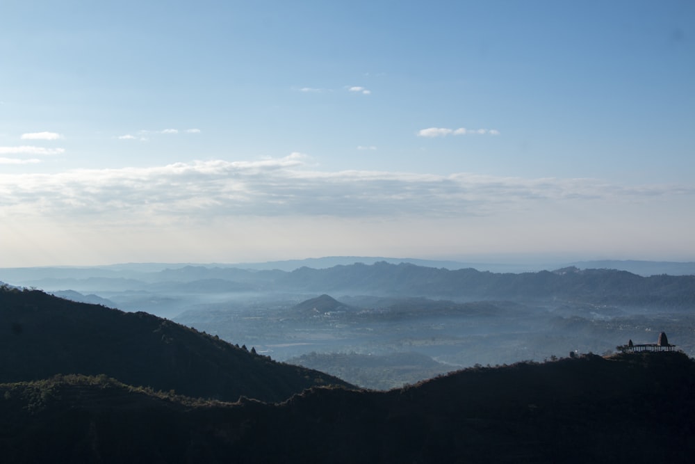 a person standing on top of a mountain overlooking a valley