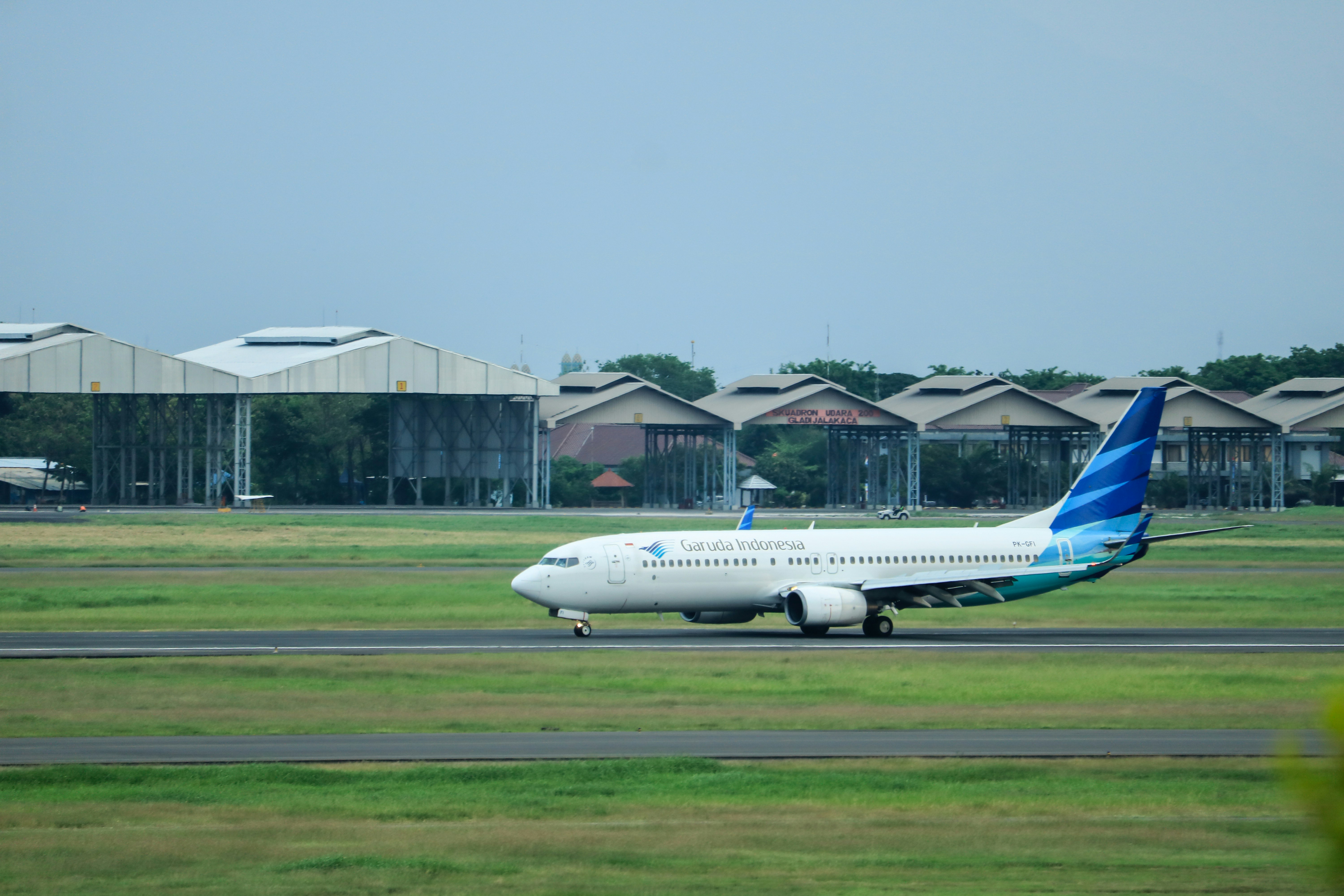 a large passenger jet sitting on top of an airport runway, Garuda Indonesia arrived in The Juanda International Airport. The plane will be parked.