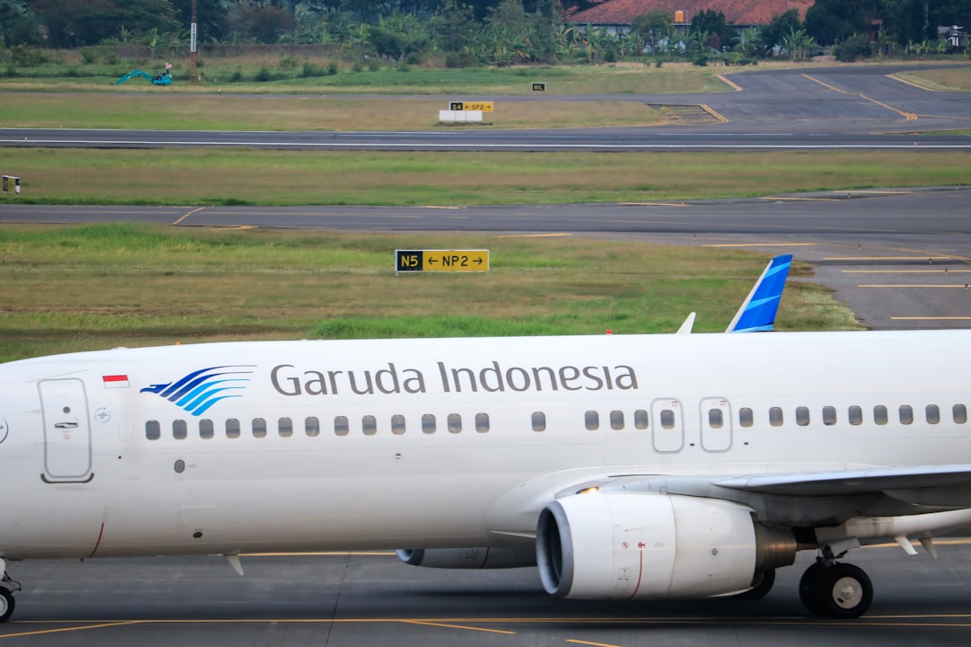 a large passenger jet sitting on top of an airport tarmac, Garuda Indonesia arrived in The Juanda International Airport.