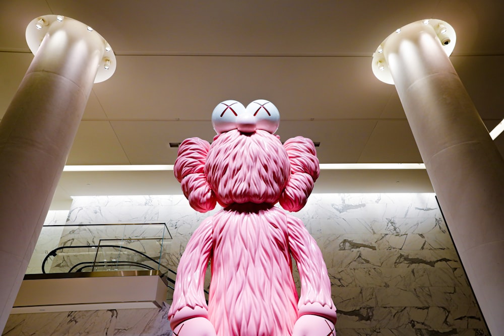a statue of a pink monster wearing sunglasses