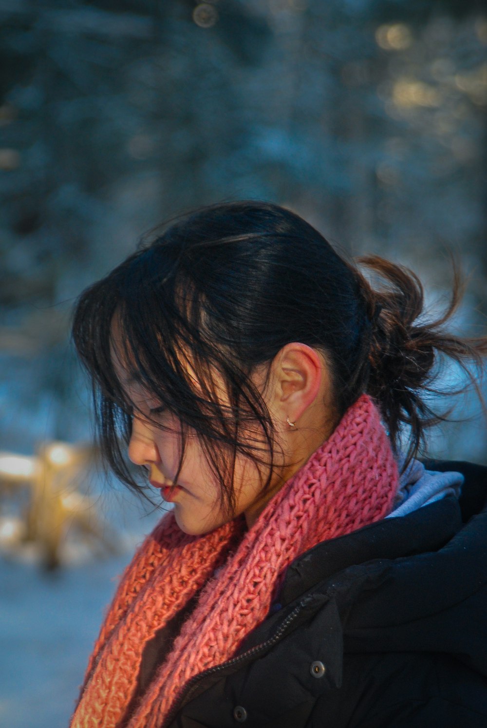 a woman wearing a scarf looking at her cell phone