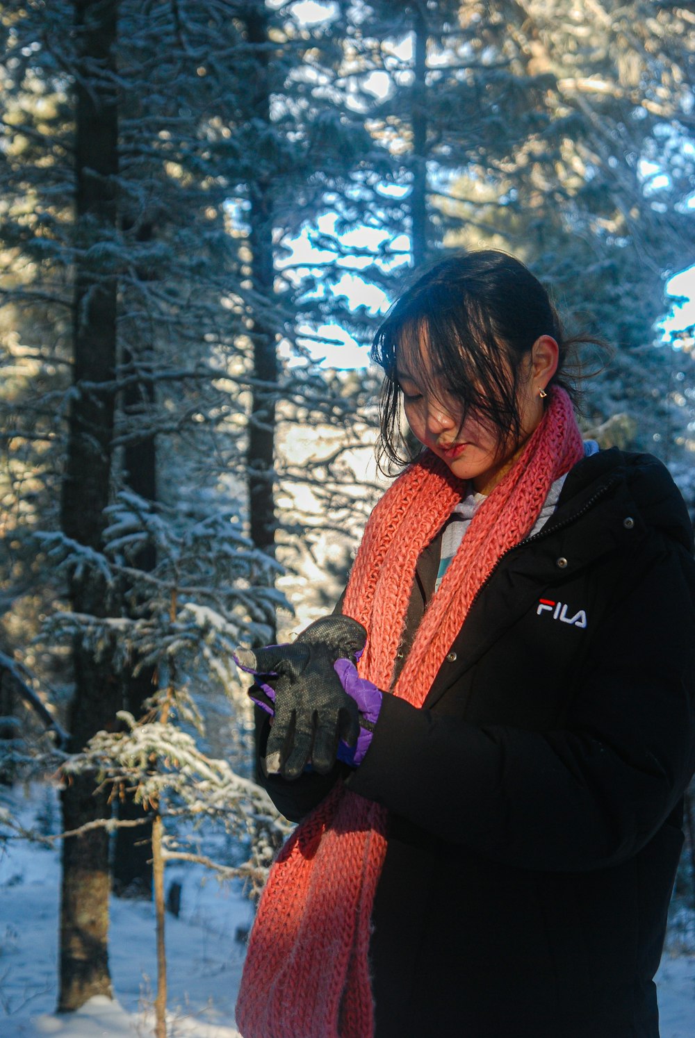 a woman wearing a scarf and gloves in the snow