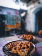 Close-up of a local dish being served at a rustic outdoor table.