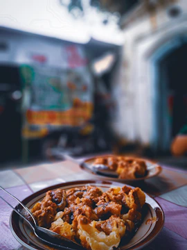 Close-up of a local dish being served at a rustic outdoor table.