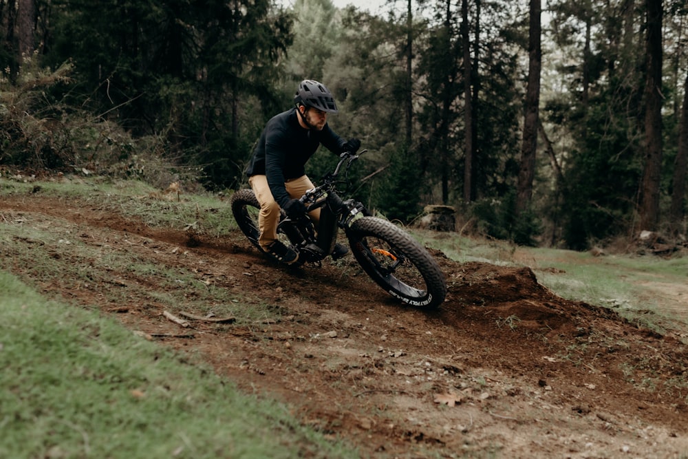 a man riding a dirt bike down a dirt road