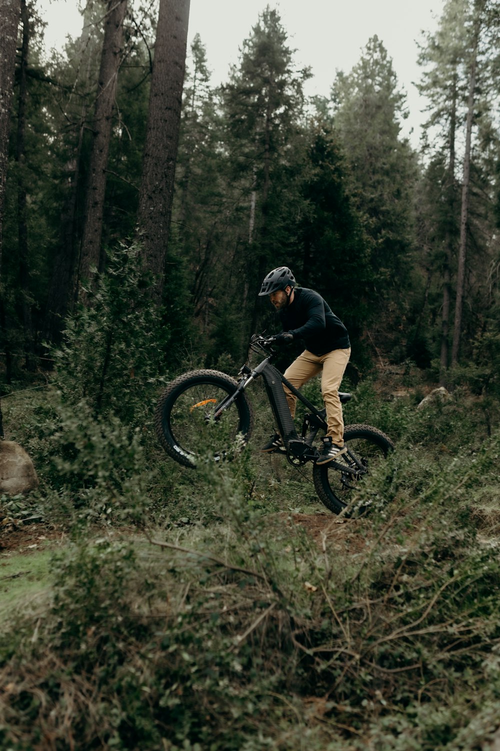 a man riding a mountain bike through a forest