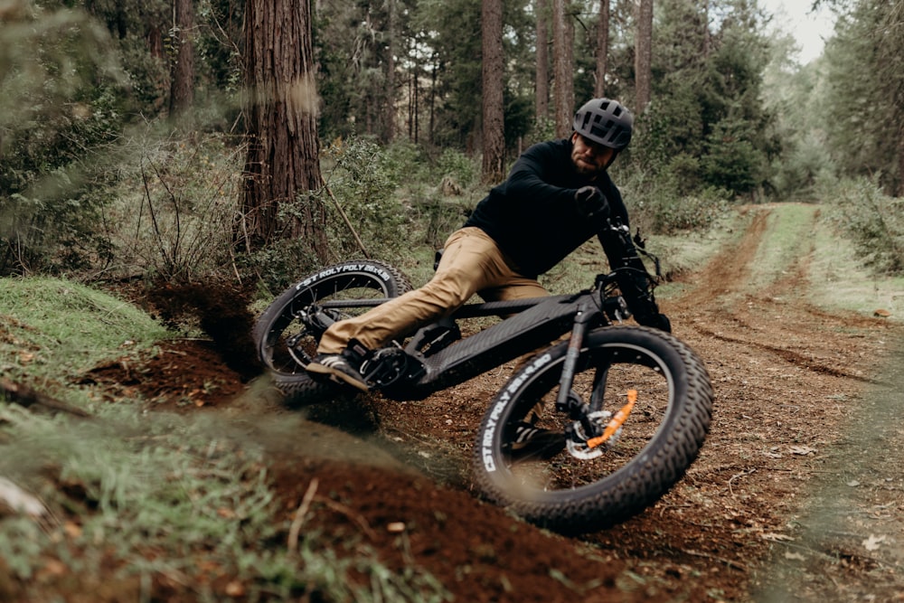 a man riding a bike down a dirt road