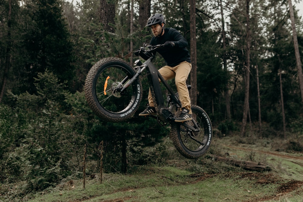 a man on a bike jumping over a tree