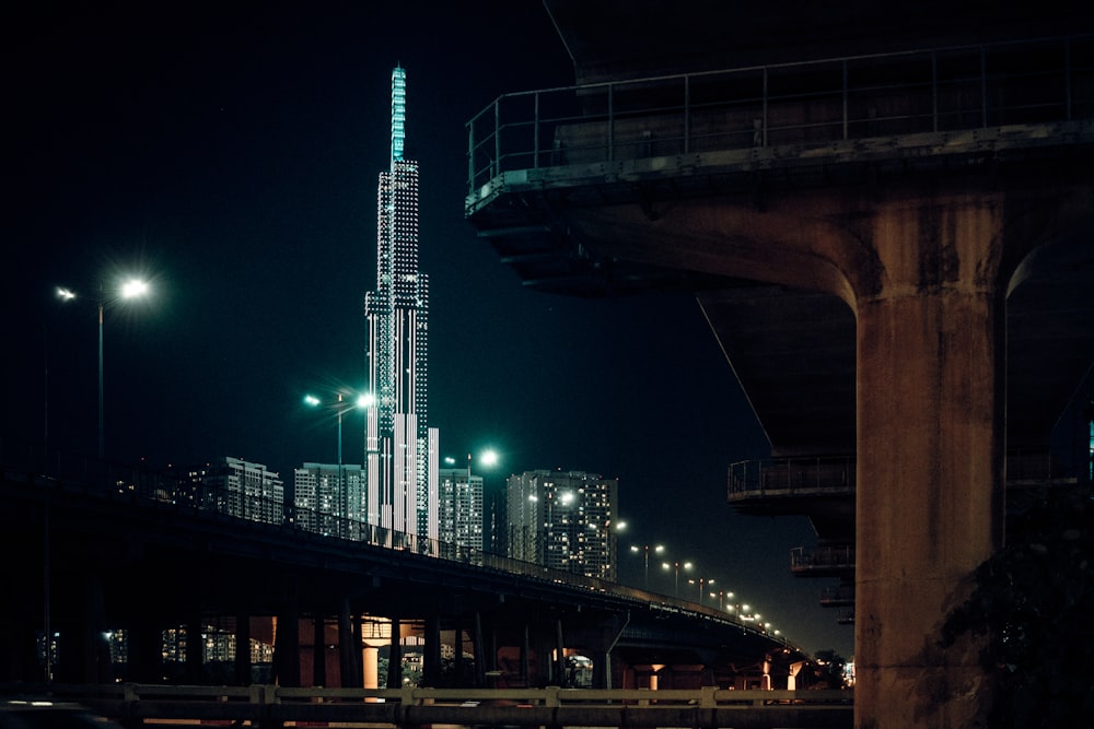 a tall building lit up at night in a city